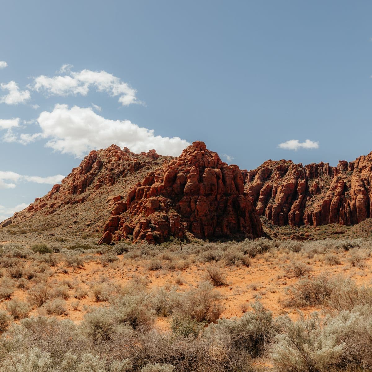 Red sandstone formations rising above sagebrush in the Utah desert